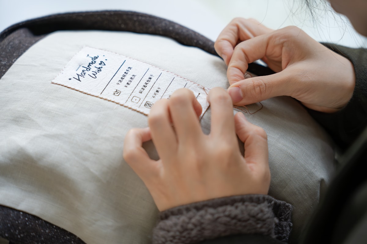 Care label with wash symbols being sewn onto a garment