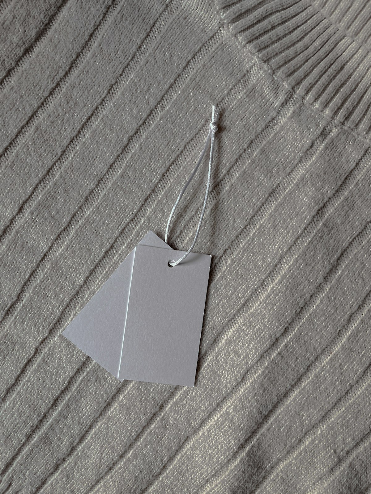 Double hang tags on a ribbed knit sweater