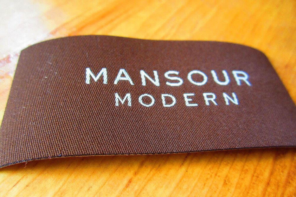 Brown woven label with Mansour Modern lettering
