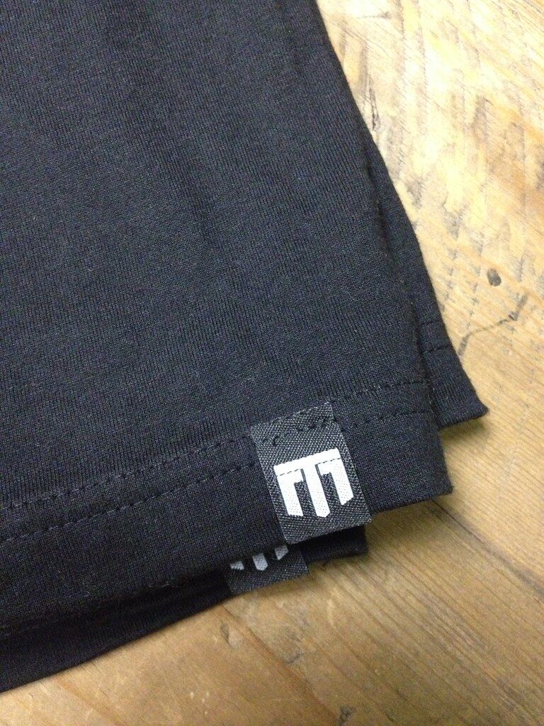 Black woven hem label sewn into a t-shirt seam