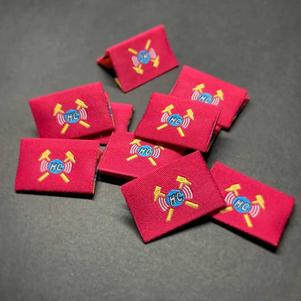 Red centerfold woven labels with a crest design