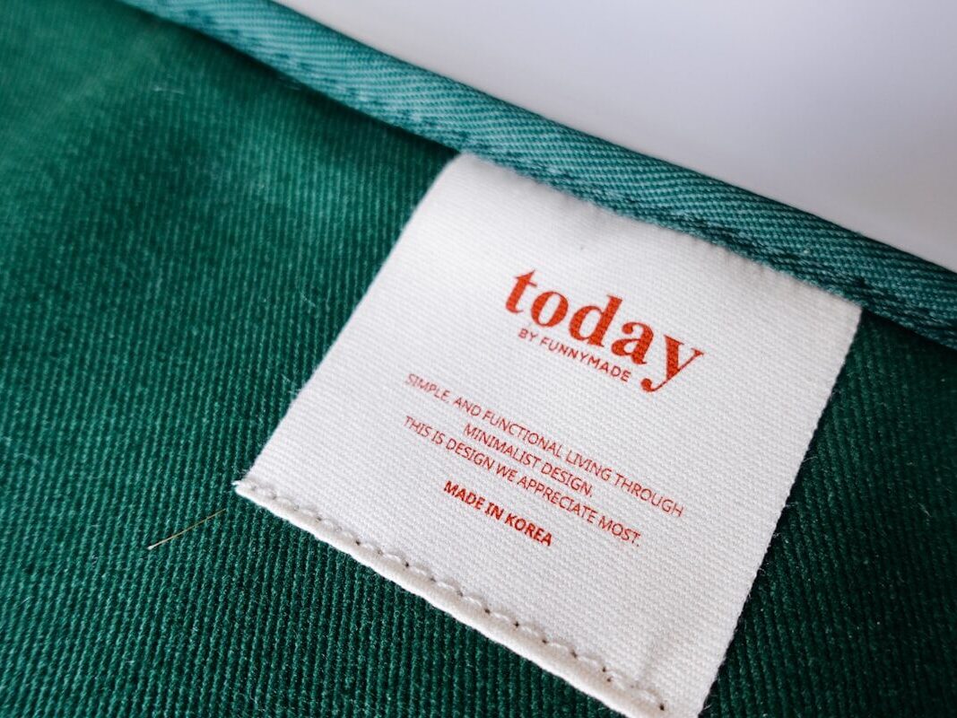 Custom printed care label stitched into a green cotton jacket