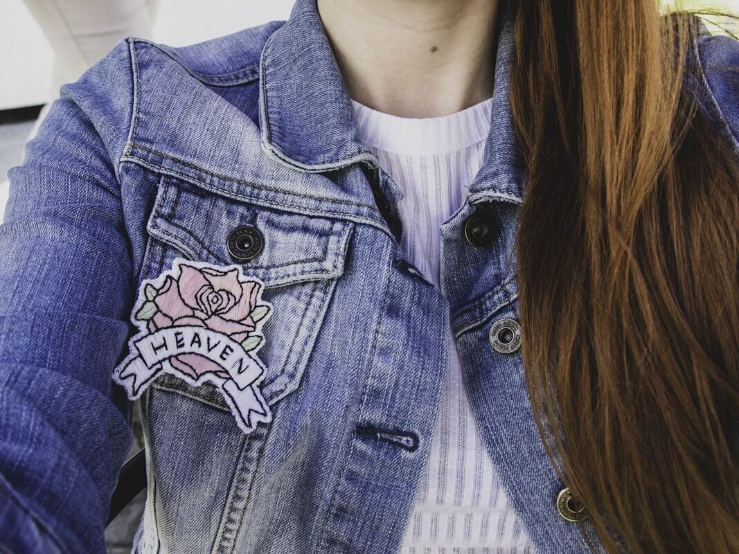 Custom woven patch sewn onto a denim jacket